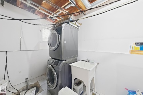 Laundry area with a utility sink and stacked appliances - 3015 37 Street Nw, Edmonton, AB 