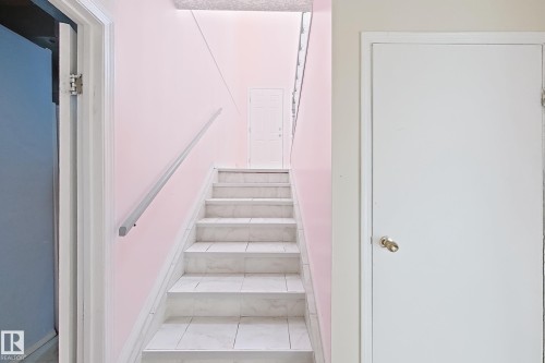 Tiled staircase with a wall-mounted handrail - 3015 37 Street Nw, Edmonton, AB 