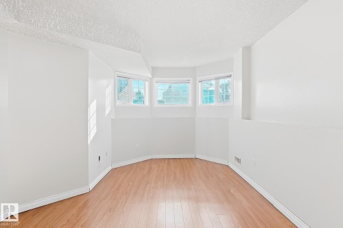 Bay window, wood-finish flooring, white walls, white trim, textured ceiling - 3015 37 Street Nw, Edmonton, AB 