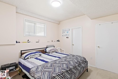 Bedroom featuring light-colored walls, white trim, and a window with horizontal blinds - 3015 37 Street Nw, Edmonton, AB 