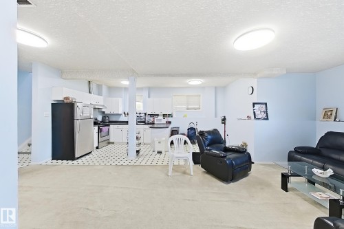 Kitchen area with white cabinetry, black countertops, and stainless steel appliances - 3015 37 Street Nw, Edmonton, AB 