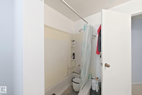 Tub/shower combination with built-in shelving and a shower curtain rod - 3015 37 Street Nw, Edmonton, AB 