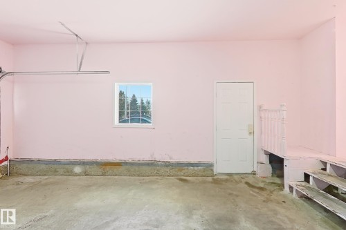 Concrete flooring, interior window, paneled door, and built-in wooden steps - 3015 37 Street Nw, Edmonton, AB 