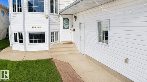 White vinyl siding exterior with a two-story bay window featuring multiple panes and substantial glazing - 3015 37 Street Nw, Edmonton, AB 