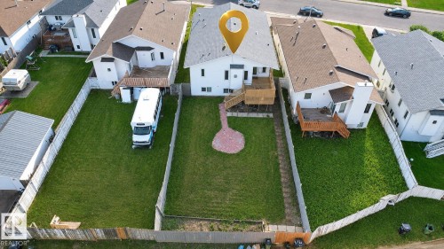Fenced property featuring a rear deck with stairs, a patio area, and a substantial yard space - 3015 37 Street Nw, Edmonton, AB 