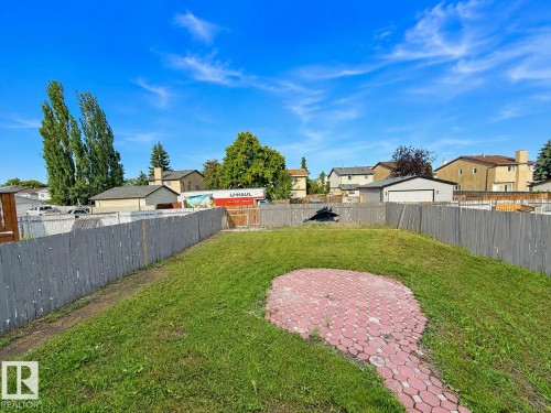 Expansive backyard with a green lawn and a red paver patio - 3015 37 Street Nw, Edmonton, AB 