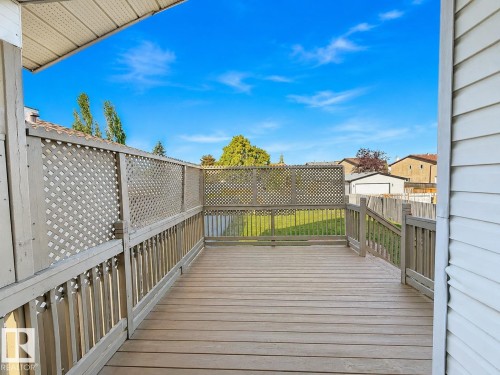 Wood-finish deck with lattice privacy screening and spindle railings - 3015 37 Street Nw, Edmonton, AB 
