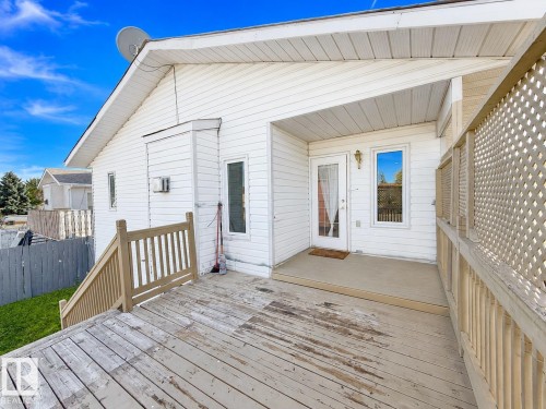 Exterior deck with wood railings, lattice privacy screen, and white vinyl siding - 3015 37 Street Nw, Edmonton, AB 