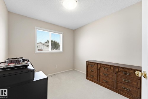 Neutral-toned walls and ceiling, light-colored carpeting, single window with white trim, flush mount ceiling light - 1709 Turvey Bend Bend Nw, Edmonton, AB 