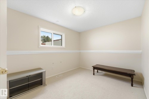 Light-colored carpeted flooring, white crown molding, white window trim, and a ceiling-mounted light fixture - 1709 Turvey Bend Bend Nw, Edmonton, AB 