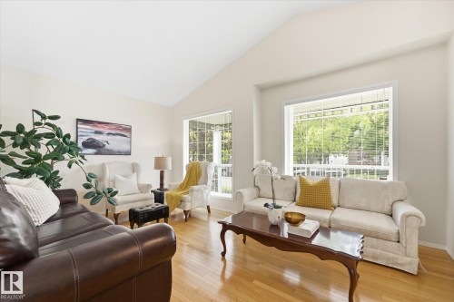 Vaulted ceiling, wood-finish flooring, large windows, white walls, and a decorative trim window - 1709 Turvey Bend Bend Nw, Edmonton, AB 