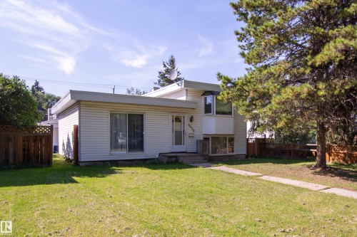 White siding exterior with a front entry, bay window, sliding glass door, and established trees - 10738 129 Street Nw, Edmonton, AB 