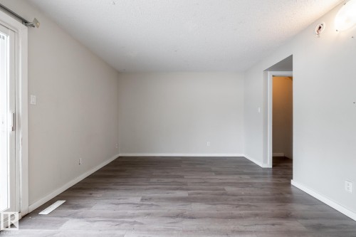 Recessed sliding glass door, wood-finish flooring, and light neutral wall color - 54 Lakewood Village Nw, Edmonton, AB 