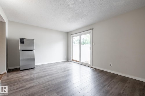 Wood-finish flooring throughout, light gray walls, and white trim - 54 Lakewood Village Nw, Edmonton, AB 