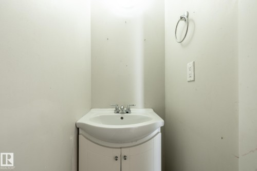 White vanity with an integrated sink, chrome faucet, and white cabinet doors - 54 Lakewood Village Nw, Edmonton, AB 