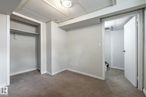 Carpeting throughout, drop panel ceiling, white wall paint, and integrated closet storage - 54 Lakewood Village Nw, Edmonton, AB 