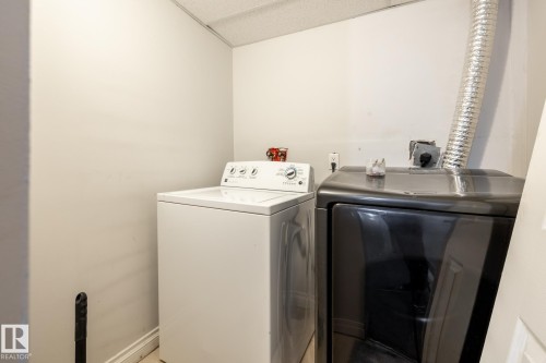 Dedicated laundry area with a top-load washing machine and front-load dryer - 54 Lakewood Village Nw, Edmonton, AB 