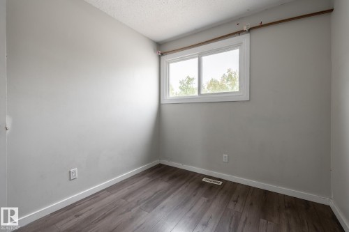 Wood-finish flooring with light gray walls and a white-framed window - 54 Lakewood Village Nw, Edmonton, AB 