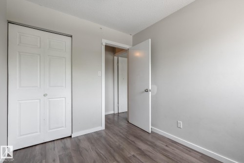 Wood-finish flooring with light gray walls, textured ceiling, and built-in bi-fold closet doors - 54 Lakewood Village Nw, Edmonton, AB 