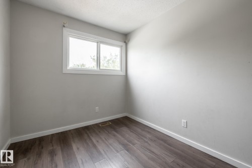 Bright interior with wood-finish flooring, white trim, and a horizontal sliding window - 54 Lakewood Village Nw, Edmonton, AB 