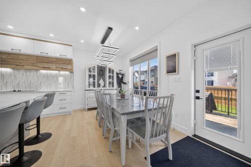 Contemporary kitchen featuring two-tone cabinetry, a tile backsplash, and recessed lighting - 17128 2 Street Nw, Edmonton, AB 