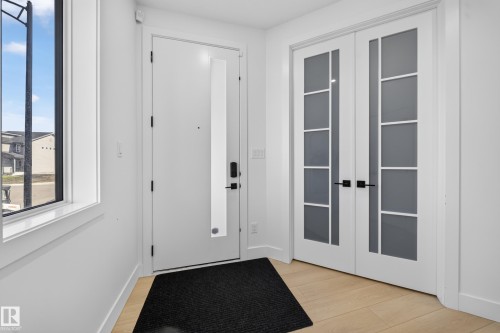 Main entrance foyer with double doors to main floor bedroom. - 17128 2 Street Nw, Edmonton, AB 