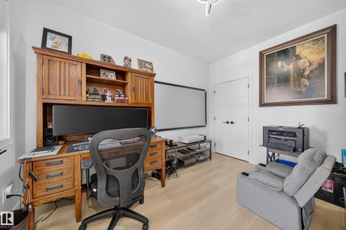 Main floor bedroom with double doors, a window & closet. - 17128 2 Street Nw, Edmonton, AB 