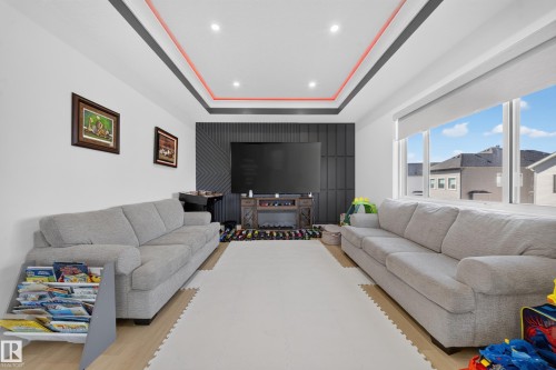2nd floor bonus room featuring indented ceiling with LED lighting, feature wall, and large West facing windows offering bright, spacious living space. - 17128 2 Street Nw, Edmonton, AB 
