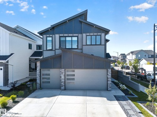 Modern architectural design featuring a multi-tone facade, large windows, and an attached two-car garage with frosted glass inserts - 17128 2 Street Nw, Edmonton, AB 