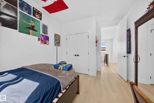Light wood-finish flooring, white walls, recessed ceiling lighting, and a dark wood-framed built-in closet - 17128 2 Street Nw, Edmonton, AB 