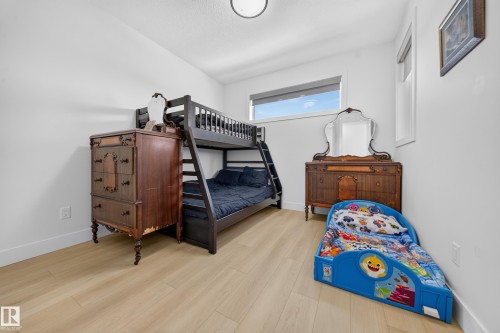 Light wood-finish flooring, white walls, recessed ceiling light, and a horizontal window with a roller shade - 17128 2 Street Nw, Edmonton, AB 