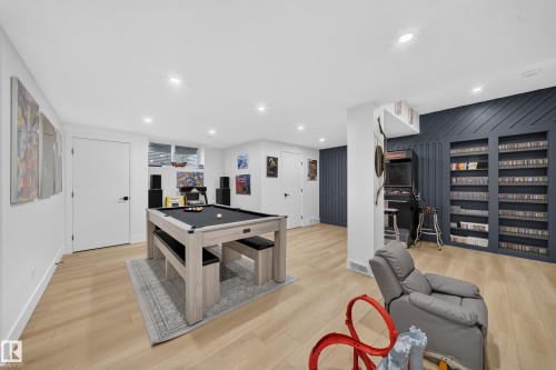 Recessed lighting illuminating the open space, light wood-finish flooring, and a dedicated storage wall with built-in shelving - 17128 2 Street Nw, Edmonton, AB 