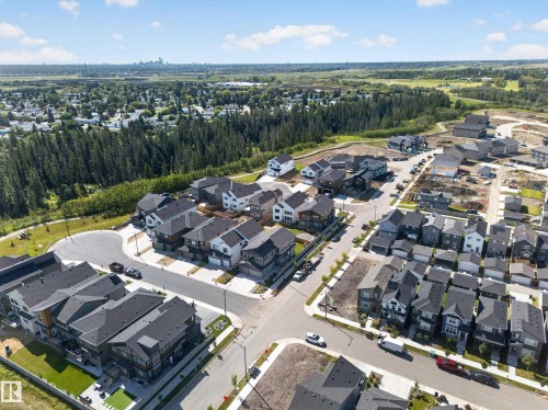 Residential development with varied architectural styles, paved roadways, and mature tree lines - 17128 2 Street Nw, Edmonton, AB 