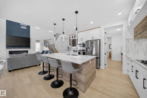 Modern kitchen island with a light-toned wood-finish base and a white countertop - 17128 2 Street Nw, Edmonton, AB 
