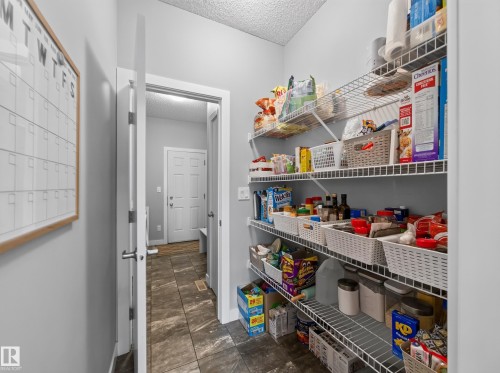 Spacious pantry featuring wire shelving, light gray walls, and tile flooring - 6504 48 Avenue, Beaumont, AB - Indoor