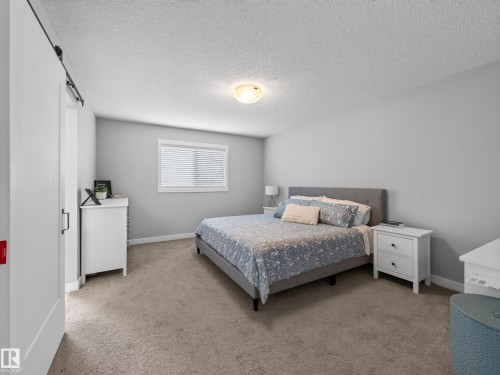 Bedroom featuring light gray walls, carpeted flooring, a flush-mount ceiling light, and a window with blinds - 6504 48 Avenue, Beaumont, AB - Indoor Photo Showing Bedroom
