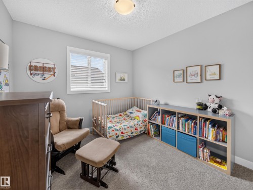 Bright room featuring light gray walls and a single window with white blinds - 6504 48 Avenue, Beaumont, AB - Indoor Photo Showing Bedroom