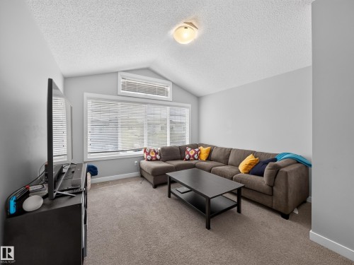 Vaulted ceiling with a flush-mount light fixture - 6504 48 Avenue, Beaumont, AB - Indoor Photo Showing Living Room