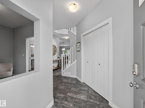 Entryway featuring dark rectangular floor tiles, light gray wall paint, and white trim - 6504 48 Avenue, Beaumont, AB - Indoor Photo Showing Other Room