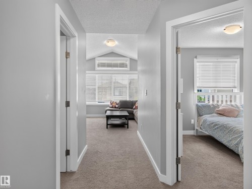 Hallway featuring neutral wall paint, carpet flooring, and white trim - 6504 48 Avenue, Beaumont, AB - Indoor Photo Showing Other Room