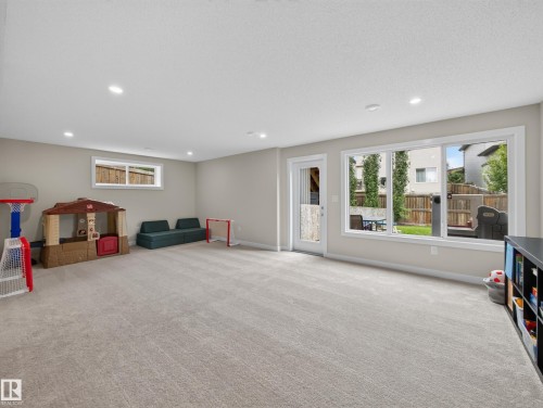 Spacious lower-level room featuring light gray carpeting, recessed ceiling lighting, and light neutral wall paint - 6504 48 Avenue, Beaumont, AB - Indoor