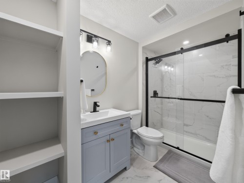 Bathroom featuring a light blue vanity with gold-tone hardware, a rectangular white sink, and a matte black faucet - 6504 48 Avenue, Beaumont, AB - Indoor Photo Showing Bathroom