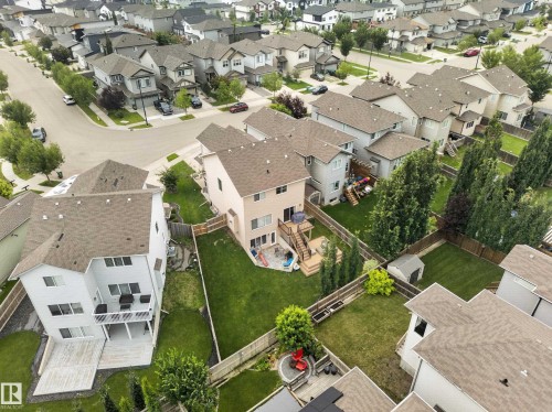 Expansive backyard featuring a manicured lawn, multi-level wood deck, and mature trees providing natural screening - 6504 48 Avenue, Beaumont, AB - Outdoor With View