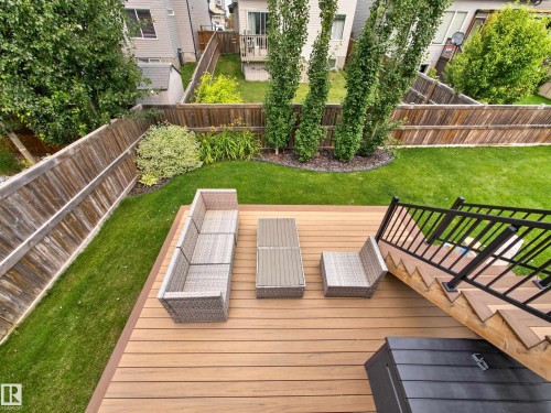 Spacious outdoor deck with wood-finish planks and matching stairs featuring black metal railings - 6504 48 Avenue, Beaumont, AB - Outdoor With Deck Patio Veranda