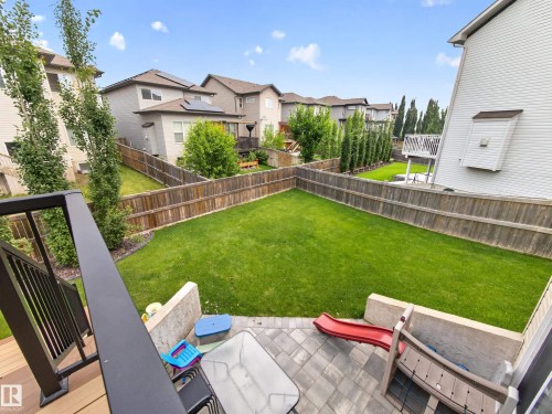 Expansive backyard featuring a lush lawn, privacy fencing, and a paver patio area - 6504 48 Avenue, Beaumont, AB - Outdoor With Backyard With Exterior
