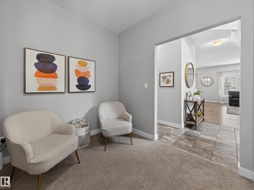 Carpeted entry area with light gray wall paint and white baseboards - 6504 48 Avenue, Beaumont, AB - Indoor