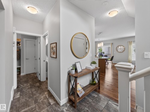 Foyer entrance featuring variegated tile flooring, a contemporary ceiling fixture, and access to a closet - 6504 48 Avenue, Beaumont, AB - Indoor Photo Showing Other Room