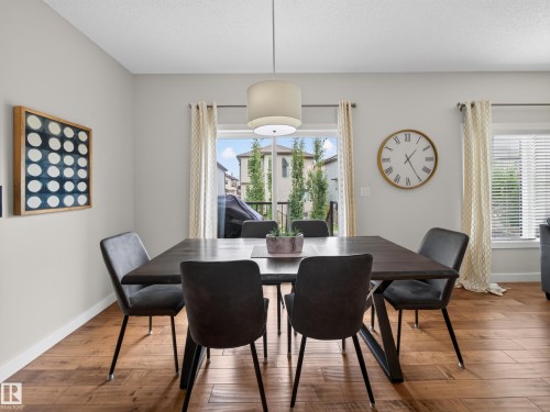 Dining area with wood-finish flooring and a contemporary pendant light fixture - 6504 48 Avenue, Beaumont, AB - Indoor Photo Showing Dining Room
