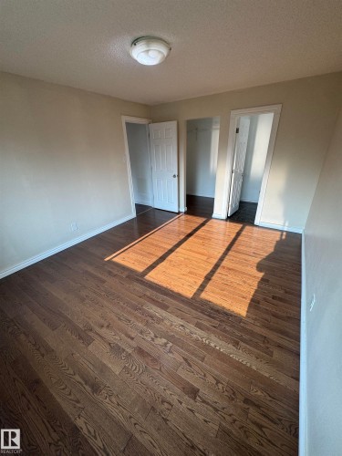 Room featuring wood-finish flooring, neutral wall tones, and white baseboards - #205 10140 151 St Nw, Edmonton, AB - Indoor Photo Showing Other Room