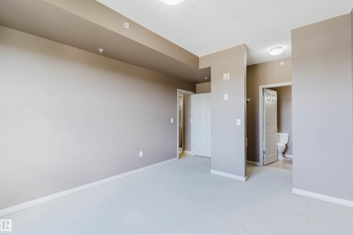 Recessed ceiling lighting, flat-panel overhead lighting fixtures, neutral wall color, white trim, and white paneled doors - #1-405 4245 139 Av Nw, Edmonton, AB 